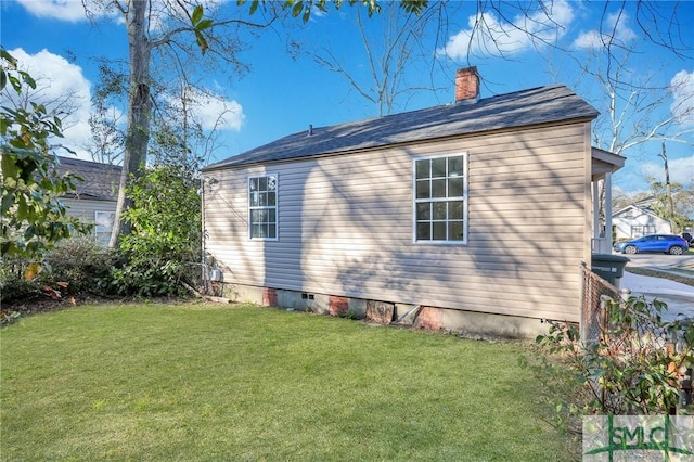 view of home's exterior featuring crawl space, a lawn, and a chimney