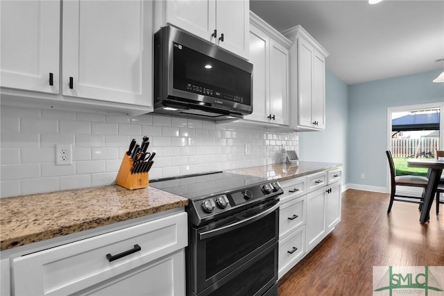 kitchen featuring range with two ovens, dark hardwood / wood-style floors, light stone countertops, decorative backsplash, and white cabinets