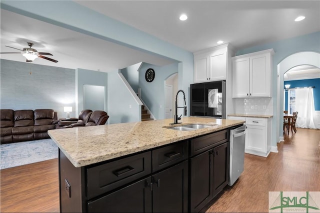 kitchen featuring sink, dishwasher, white cabinetry, light hardwood / wood-style floors, and an island with sink