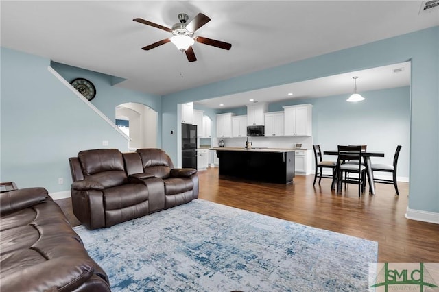 living room with ceiling fan and dark hardwood / wood-style floors