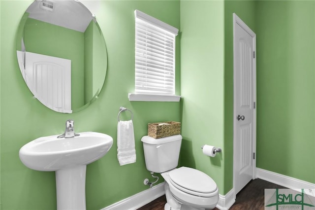 bathroom with hardwood / wood-style flooring and toilet