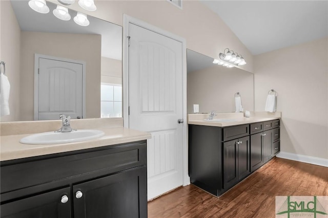 bathroom featuring wood-type flooring, lofted ceiling, and vanity