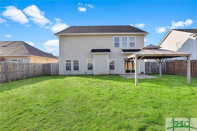 rear view of house with a yard, a gazebo, and a patio