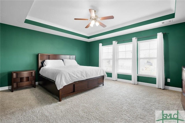 bedroom with a tray ceiling, carpet floors, and ceiling fan