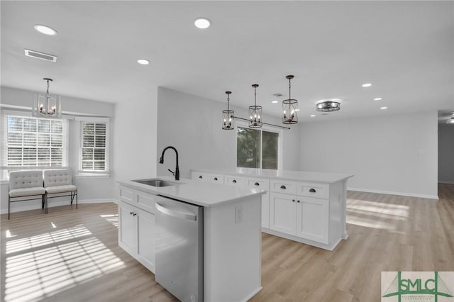 kitchen with sink, white cabinetry, stainless steel dishwasher, pendant lighting, and a kitchen island with sink