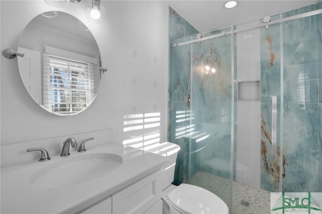 bathroom with vanity, toilet, and a shower with shower door