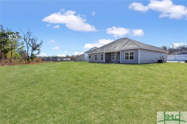 rear view of property with central AC unit and a lawn