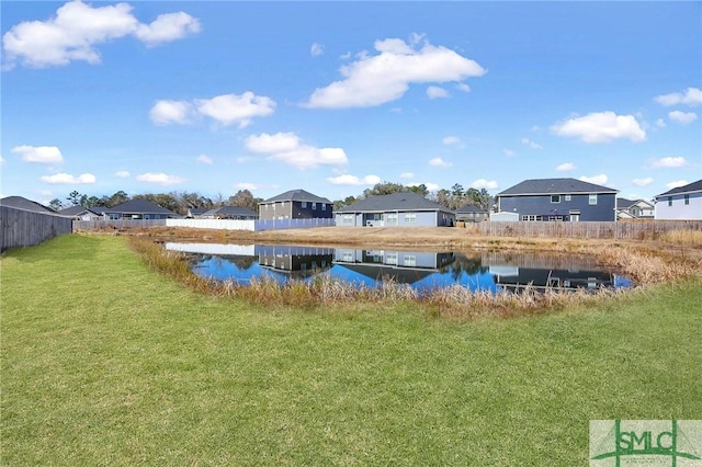 view of pool with a water view and a yard