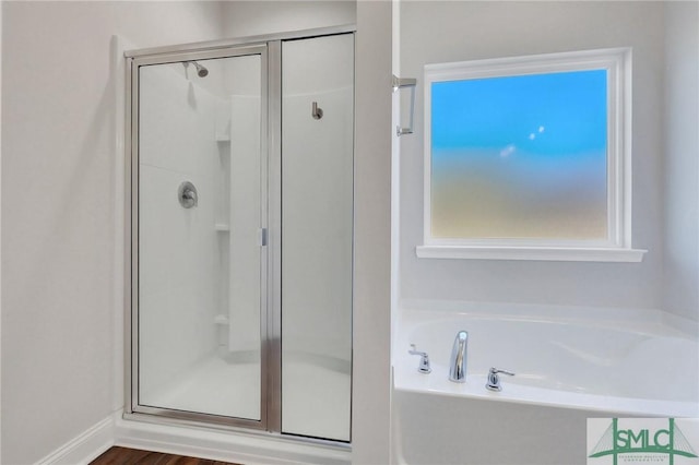 bathroom featuring shower with separate bathtub