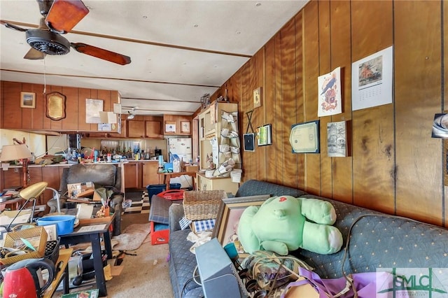 misc room featuring ceiling fan, light colored carpet, and wooden walls