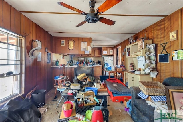 interior space with ceiling fan and wood walls