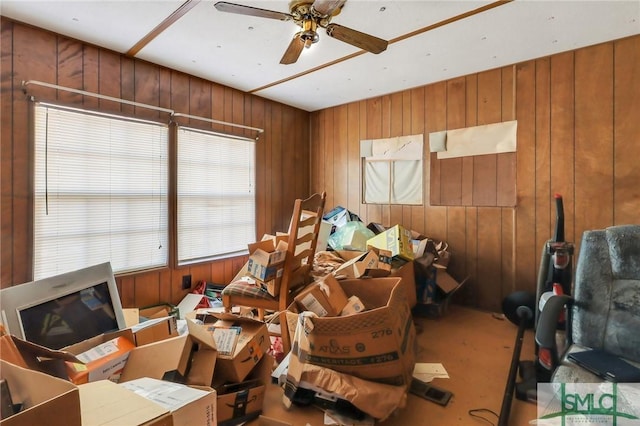 miscellaneous room with ceiling fan and wooden walls