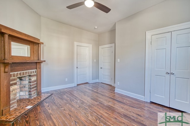 unfurnished living room with ceiling fan, hardwood / wood-style floors, and a fireplace