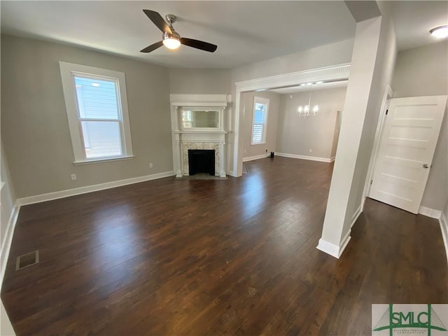 unfurnished living room with dark hardwood / wood-style floors and ceiling fan with notable chandelier