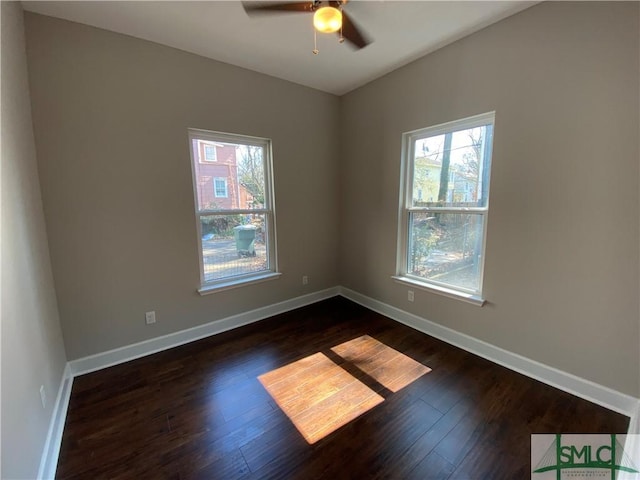 spare room featuring ceiling fan, a healthy amount of sunlight, and dark hardwood / wood-style flooring