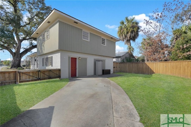 back of property with central AC and a yard