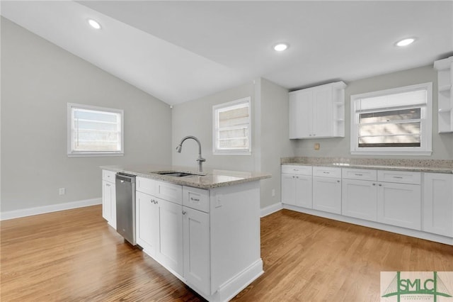 kitchen with light stone counters, sink, stainless steel dishwasher, and white cabinets