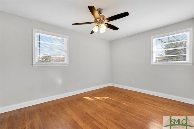 spare room featuring plenty of natural light, hardwood / wood-style floors, and ceiling fan