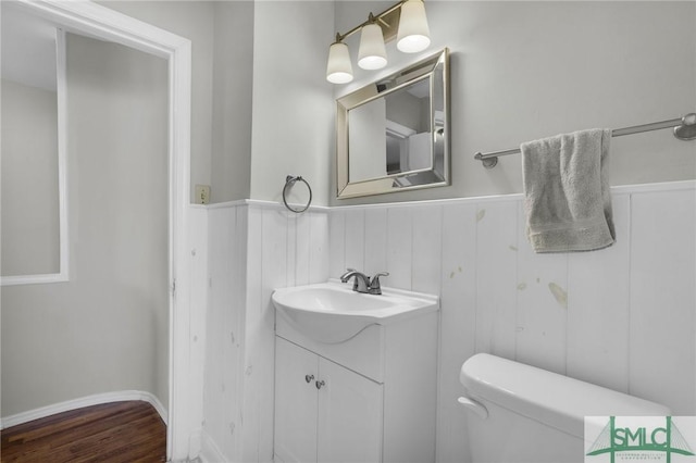 bathroom with vanity, toilet, and wood-type flooring