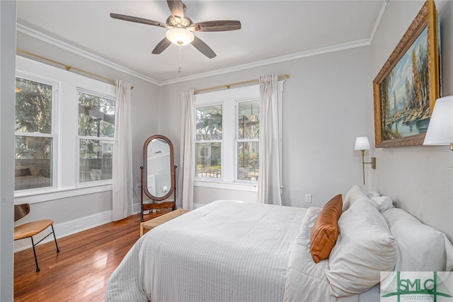 bedroom with multiple windows, crown molding, and wood-type flooring