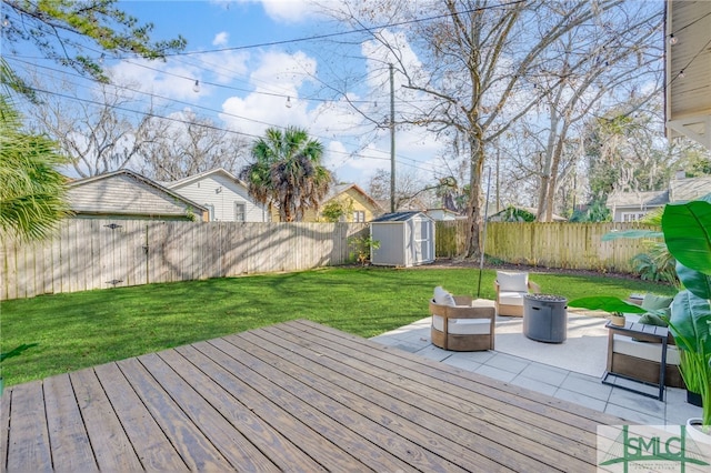 wooden deck featuring a storage shed, a yard, and a patio