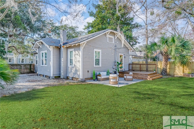 back of house with an outdoor living space, a deck, a patio, and a lawn