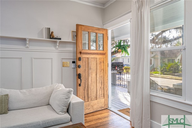 entrance foyer featuring ornamental molding, wood-type flooring, and a wealth of natural light