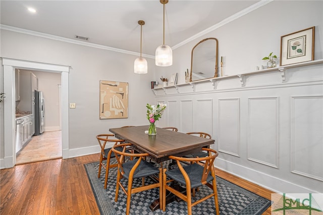 dining space featuring hardwood / wood-style floors and ornamental molding