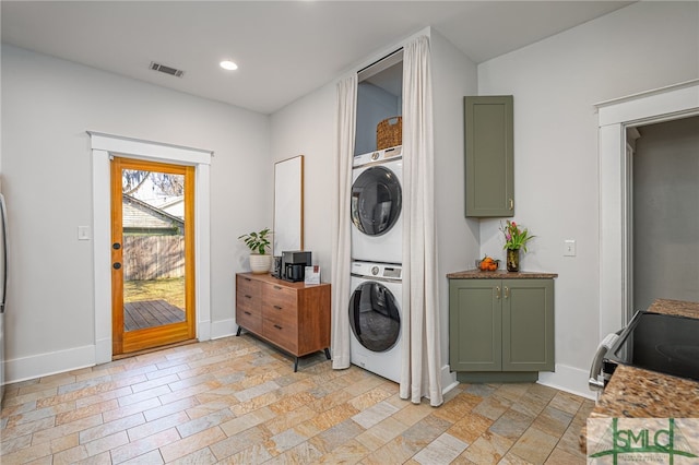 clothes washing area featuring stacked washer / dryer