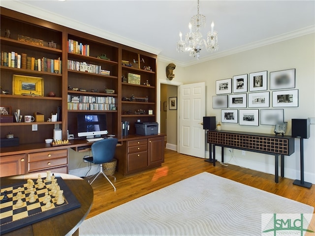 office featuring hardwood / wood-style flooring, crown molding, built in desk, and a notable chandelier