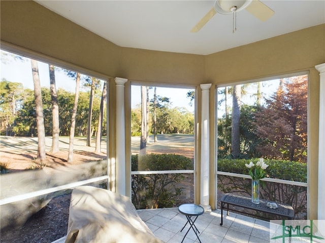 sunroom featuring ceiling fan and decorative columns