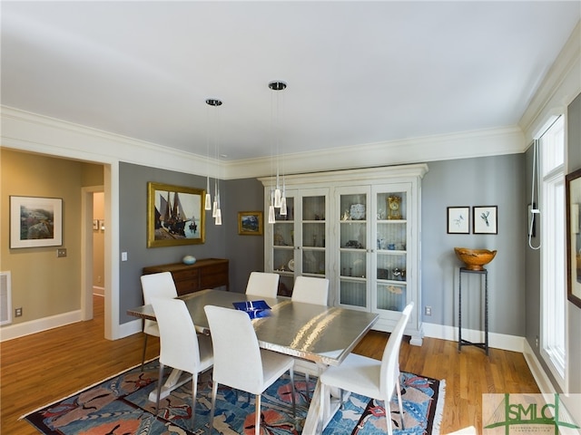 dining area featuring ornamental molding and light wood-type flooring