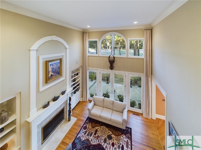 living room with crown molding and light hardwood / wood-style floors