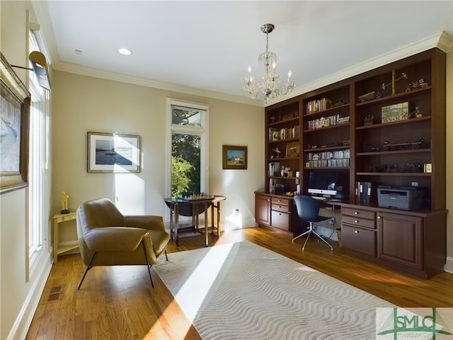 home office featuring hardwood / wood-style flooring, ornamental molding, a healthy amount of sunlight, and a notable chandelier