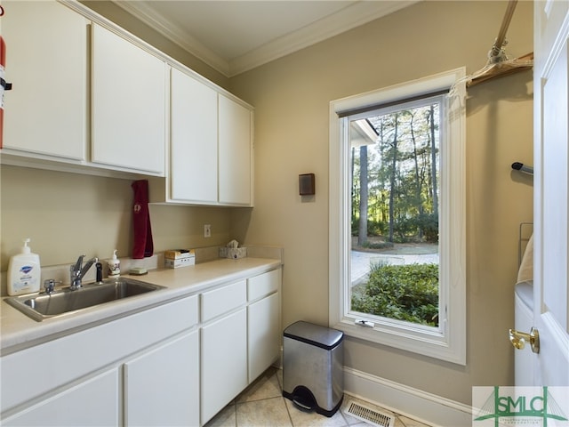 kitchen with white cabinetry, crown molding, sink, and light tile patterned floors