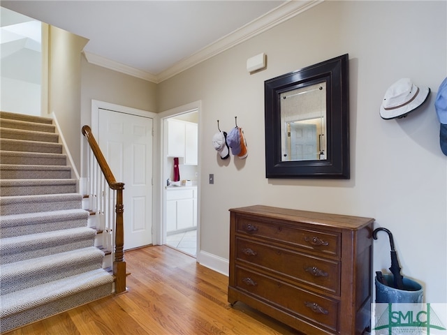 entrance foyer with crown molding and light hardwood / wood-style flooring