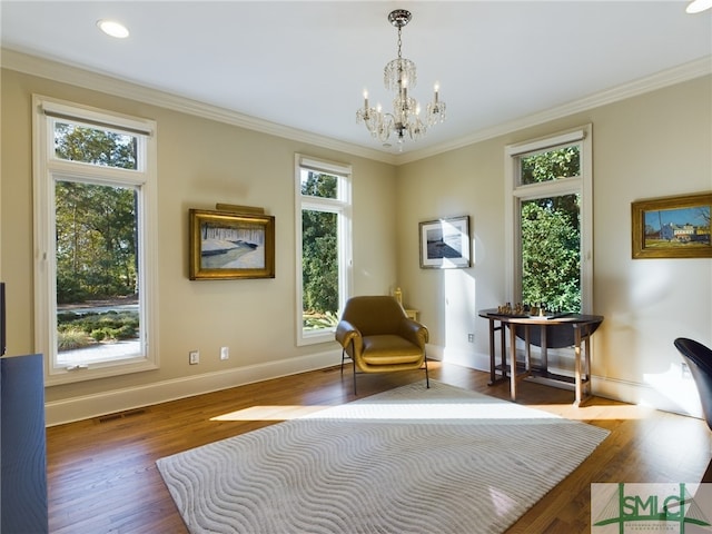 sitting room with an inviting chandelier, ornamental molding, and dark hardwood / wood-style flooring