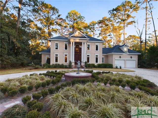 neoclassical home featuring a garage