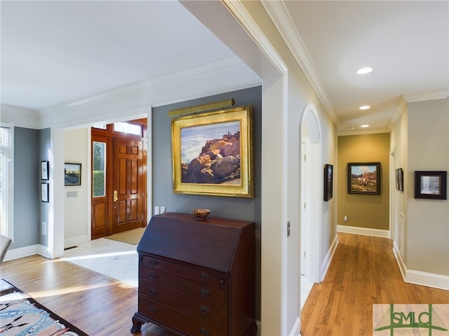 hall with ornamental molding and light wood-type flooring