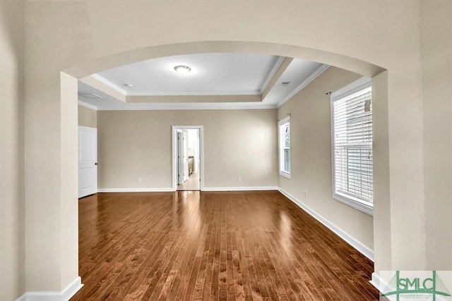 unfurnished room with crown molding, dark hardwood / wood-style flooring, and a raised ceiling