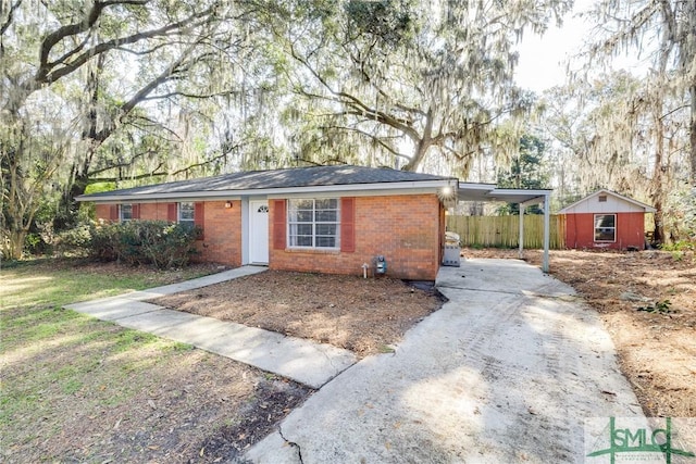 ranch-style home featuring a carport and a shed