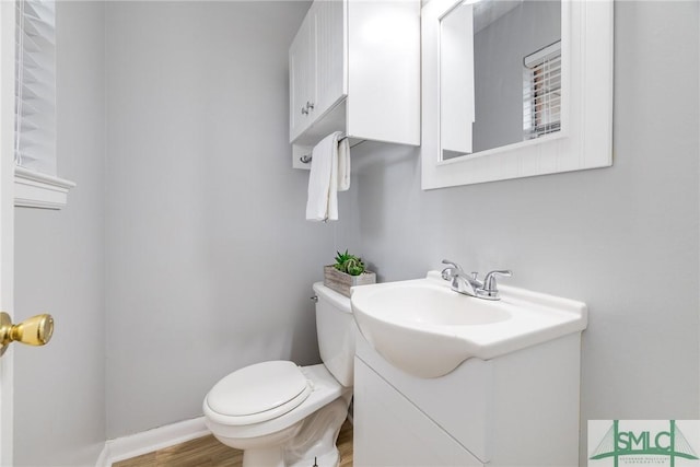 bathroom featuring vanity, hardwood / wood-style flooring, and toilet