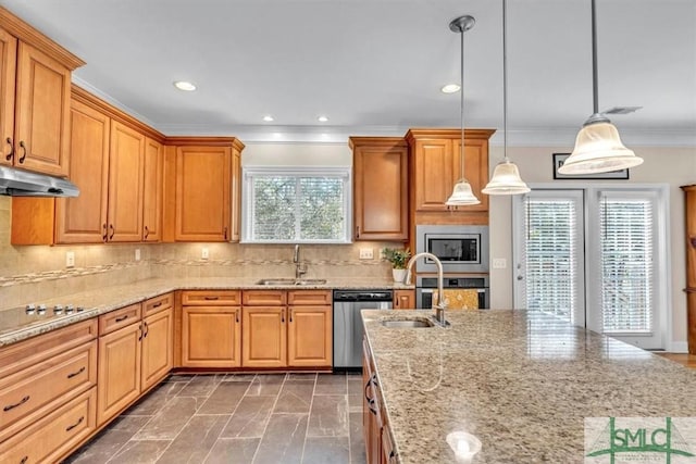 kitchen featuring pendant lighting, sink, backsplash, stainless steel appliances, and light stone countertops