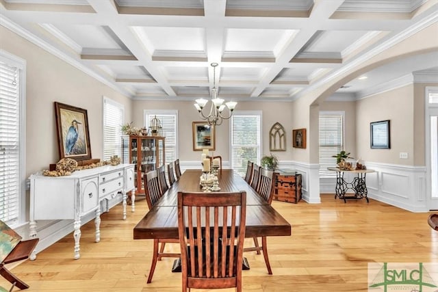 dining area featuring coffered ceiling, an inviting chandelier, crown molding, light wood-type flooring, and beam ceiling