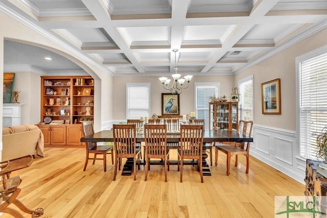 dining area with beamed ceiling, coffered ceiling, and light hardwood / wood-style flooring