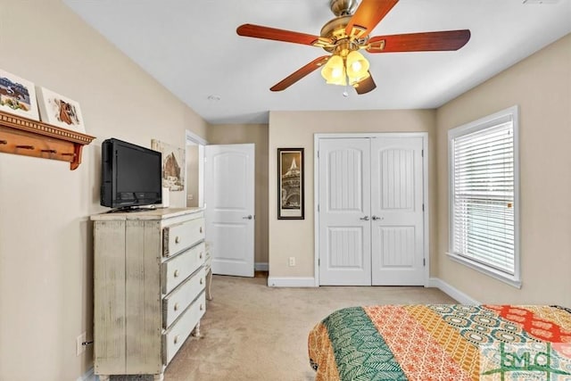 unfurnished bedroom with light carpet, a closet, and ceiling fan