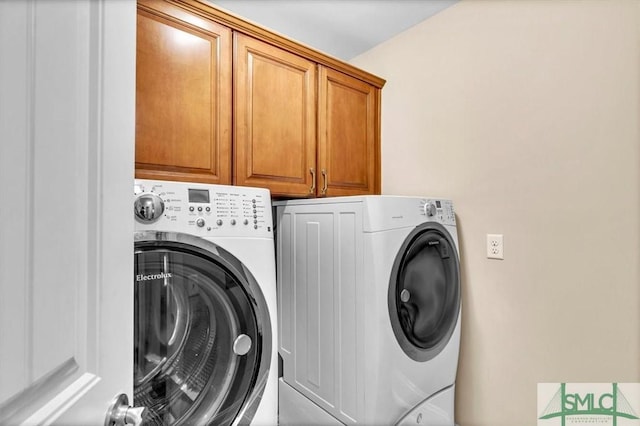 washroom featuring cabinets and washing machine and clothes dryer