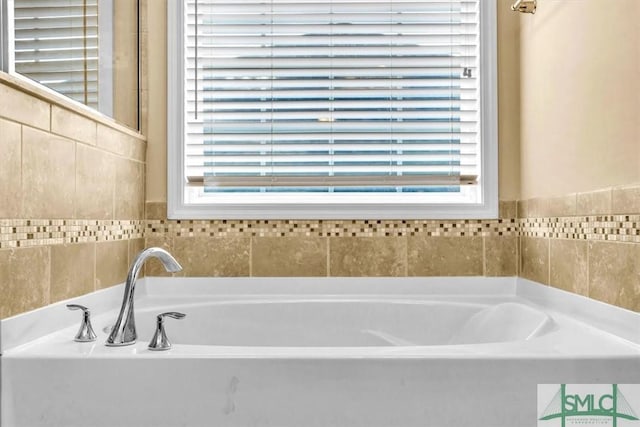 bathroom featuring a tub and a wealth of natural light