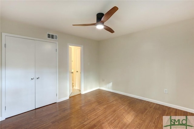 unfurnished bedroom featuring hardwood / wood-style flooring, a closet, and ceiling fan