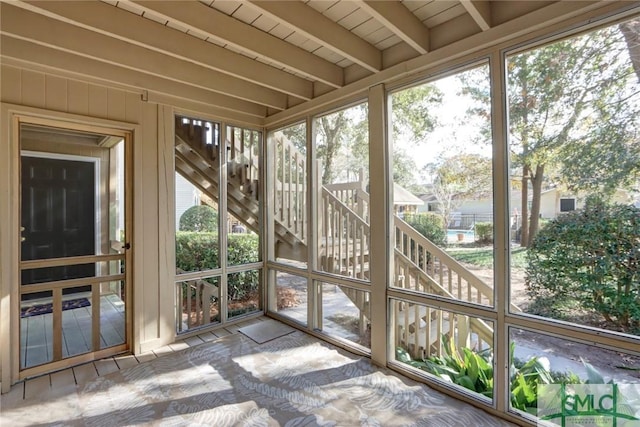 unfurnished sunroom with beam ceiling